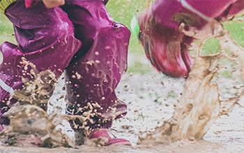 Children jumping in puddle